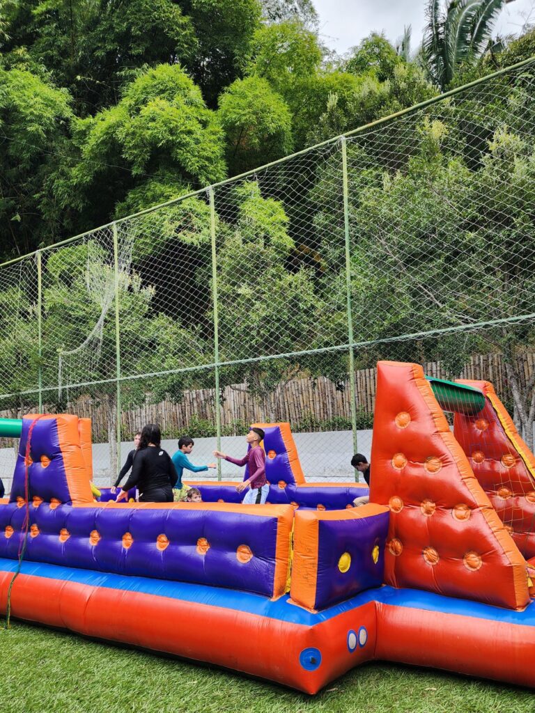 Crianças brincando em um pula-pula inflável em um espaço aberto. Uma das atrações do mês de outubro no Arajara Park.