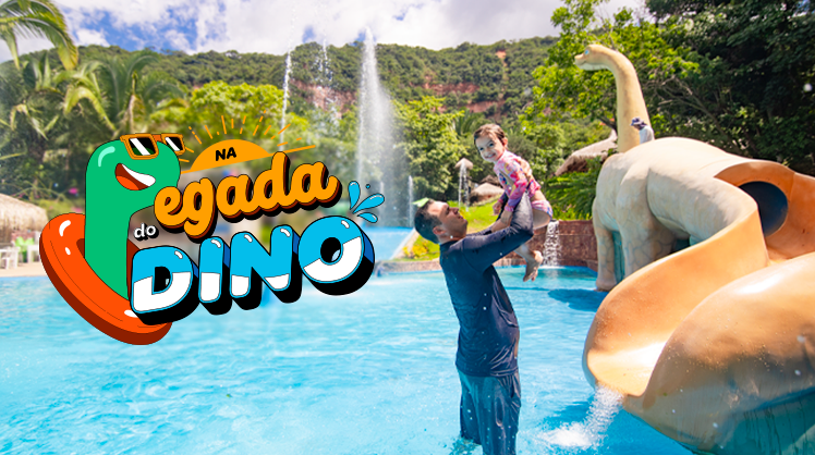 Pai com sua filha aproveitando a piscina próximo ao toboágua de dino.