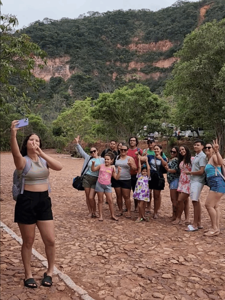 Grupo de pessoas em meio a espaço amplo tirando uma foto
