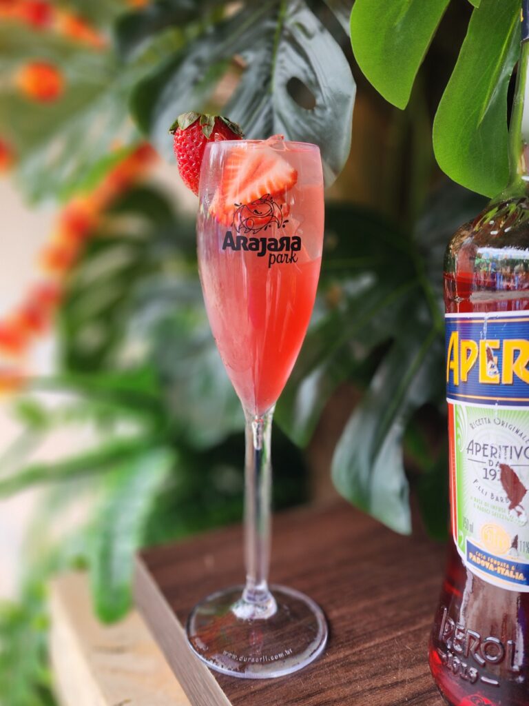 Foto em close de uma taça com uma bebida de morango.