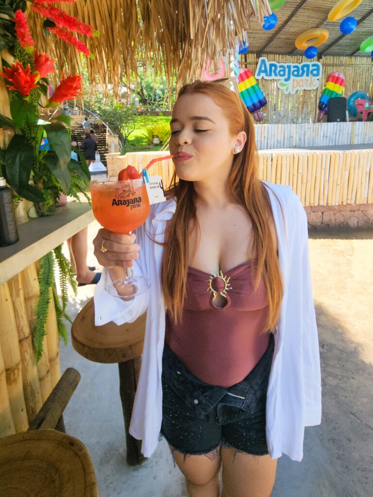 Foto de pessoa tomando drink em uma taça.